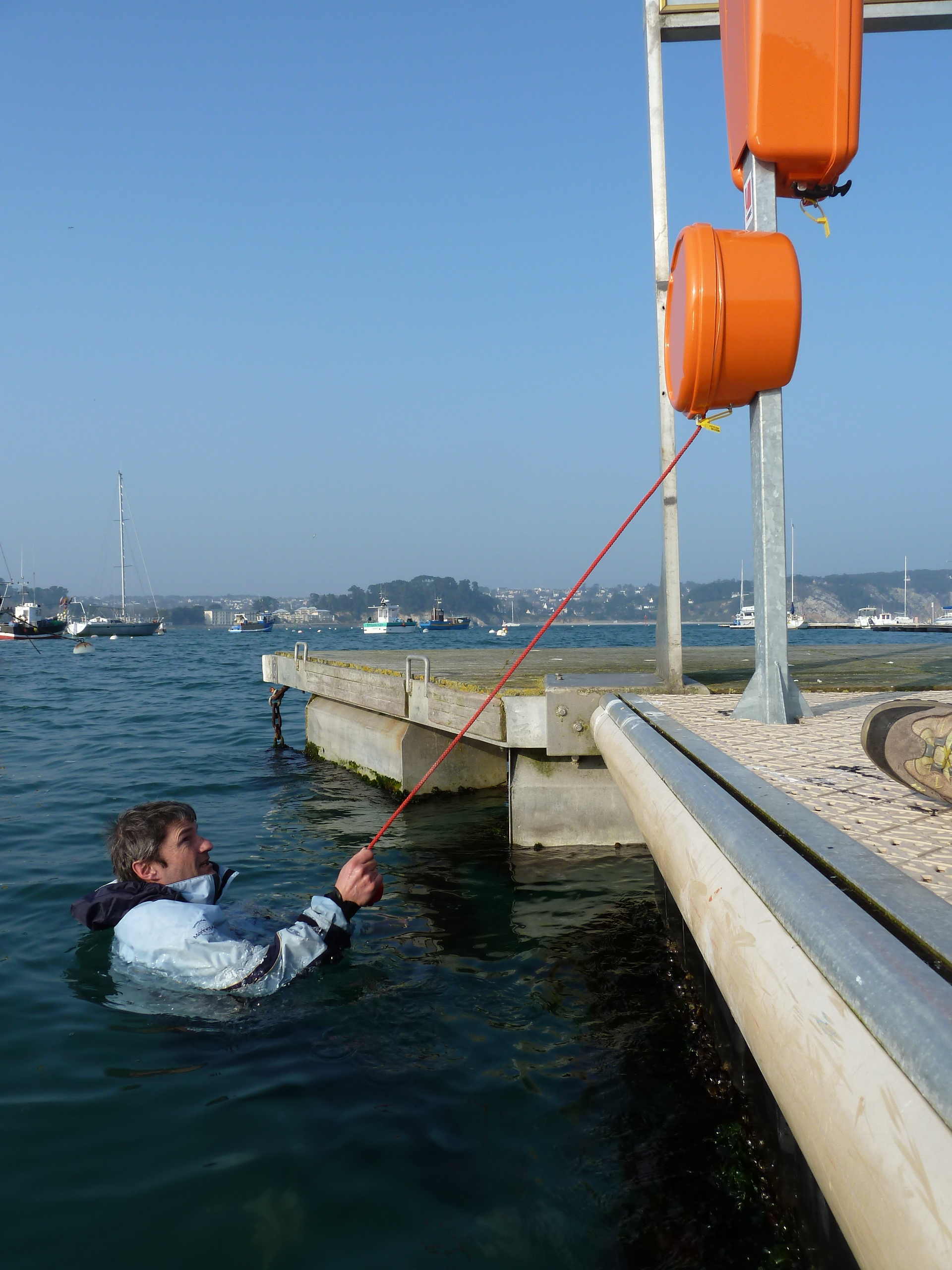 Echelle de secours contenue dans le boitier orange, la personne tombée à l'eau tire sur le cordage et permet alors le deploiement de l'échelle